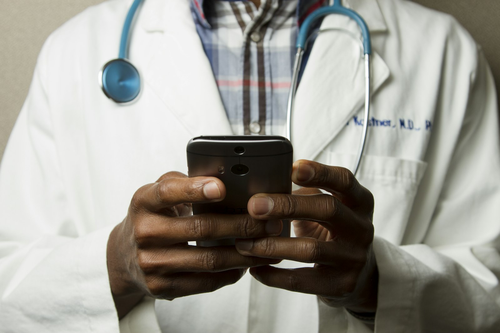 Doctor revisando su teléfono, representando el acceso al seguro médico